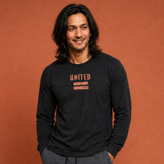 His Good Stuff's Autumn Catalog HGS26S4 United Equality, front, close up, heavyweight, 100% ring-spun cotton, black, long-sleeve, detail of fabric against a flat Brandied Melon background. Graphic displays two bars beneath the distressed letters "EQUALITY".