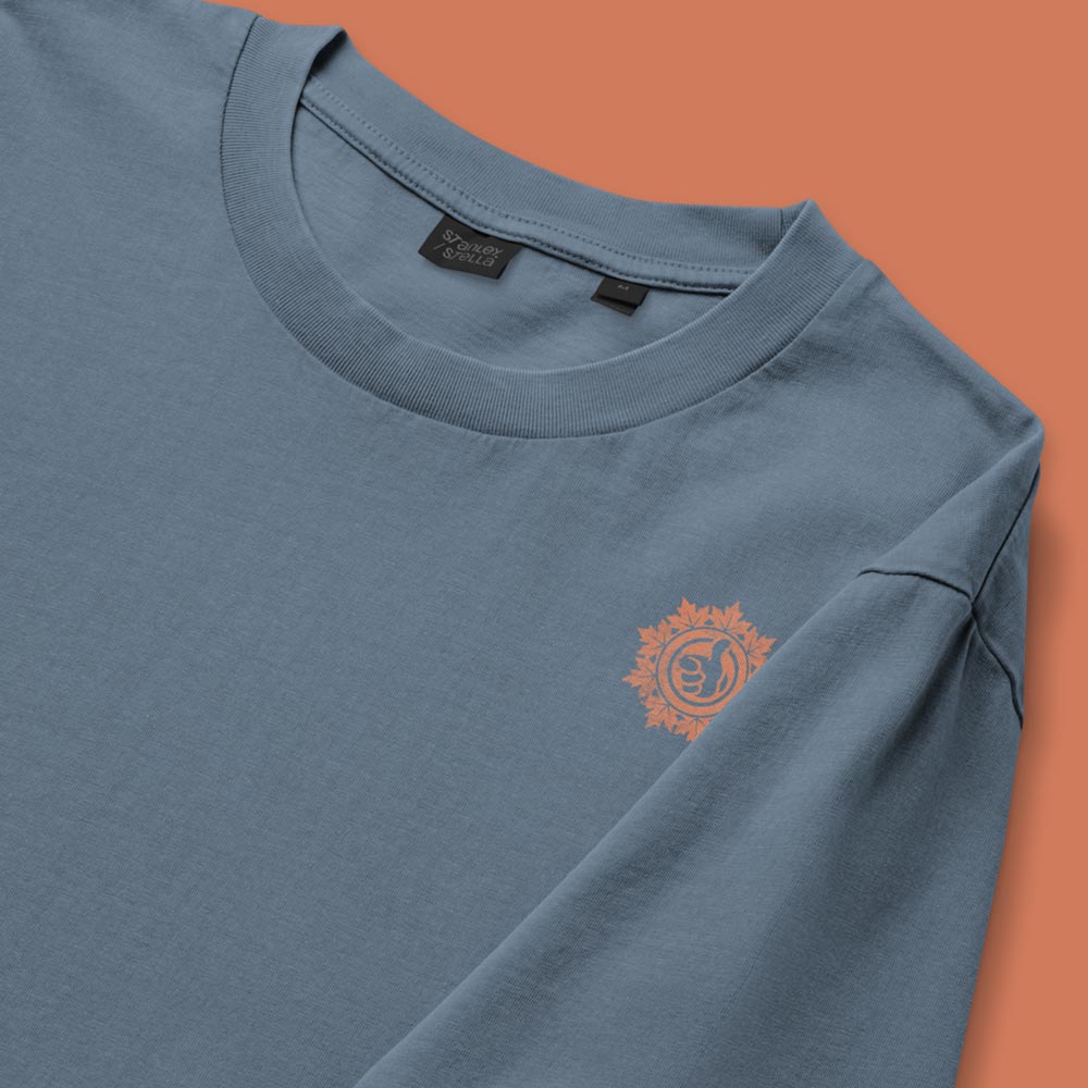 His Good Stuff's Autumn Catalog HGS26S4 Autumn Tee, front fabric detail, relaxed fit, 100% ring-spun cotton, grey, short-sleeve, against a flat Brandied Melon background. Graphic displays in the top right a small HGS Fall thumbs-up icon