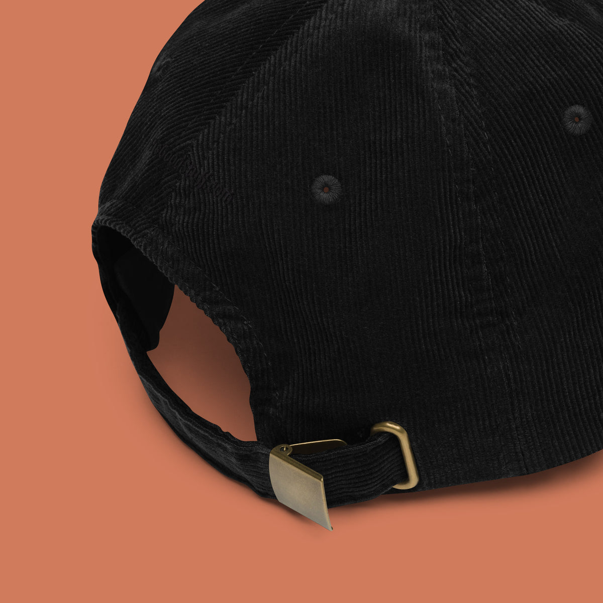 His Good Stuff's Autumn Catalog HGS26S4 Corduroy Cap, back view, 100% cotton corduroy with an adjustable golden buckle in the back, on a model against a flat Brandied Melon background. 