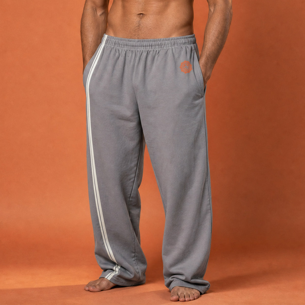 His Good Stuff's Autumn Catalog HGS26S4 Cotton Pants, front closeup, wide-leg, heavyweight cotton-spandex blend, ultimate grey with 2 cloud dancer white stripes, on a model against a flat Brandied Melon background. Graphic displays in the top right a brandied-melon-colored HGS Fall thumbs-up icon.