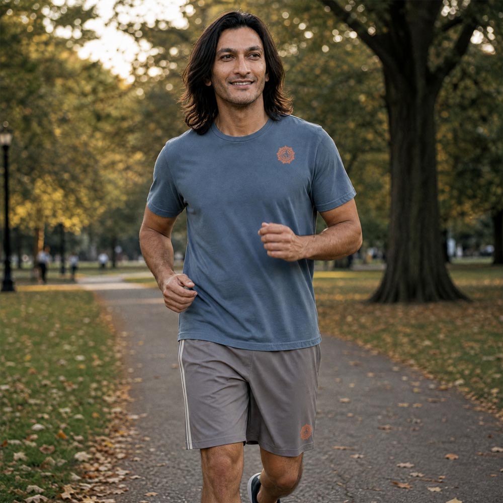 His Good Stuff's Autumn Catalog HGS26S4 Cotton Shorts, front, Long Shorts, heavyweight cotton-spandex blend, driftwood with 2 light grey stripes, on a model walking outside in a city park in the Fall. Graphic displays in the lower right a brandied-melon-colored HGS Fall thumbs-up icon.