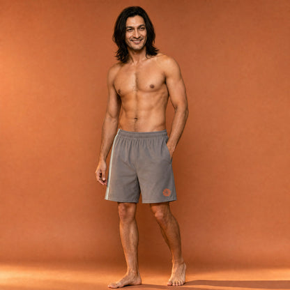 His Good Stuff's Autumn Catalog HGS26S4 Cotton Shorts, front, Long Shorts, heavyweight cotton-spandex blend, driftwood with 2 light grey stripes, on a model against a flat Brandied Melon background. Graphic displays in the lower right a brandied-melon-colored HGS Fall thumbs-up icon.