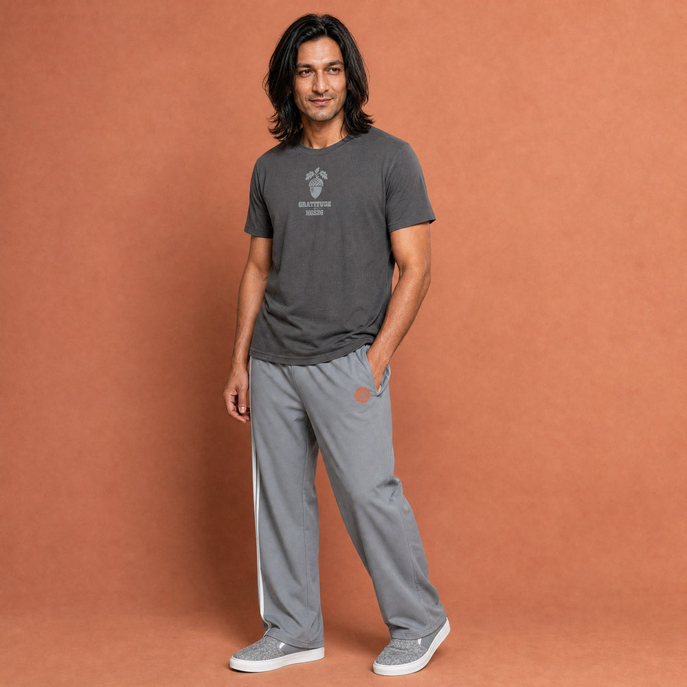 His Good Stuff's Autumn Catalog HGS26S4 Gratitude Tee, front, relaxed fit, 100% ring-spun cotton, grey, short-sleeve, front, on a model against a flat Brandied Melon background. Graphic displays an acorn graphic above the letters "GRATITUDE" and "HGS26S4".