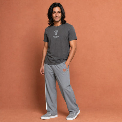 His Good Stuff's Autumn Catalog HGS26S4 Gratitude Tee, front, relaxed fit, 100% ring-spun cotton, grey, short-sleeve, front, on a model against a flat Brandied Melon background. Graphic displays an acorn graphic above the letters "GRATITUDE" and "HGS26S4".
