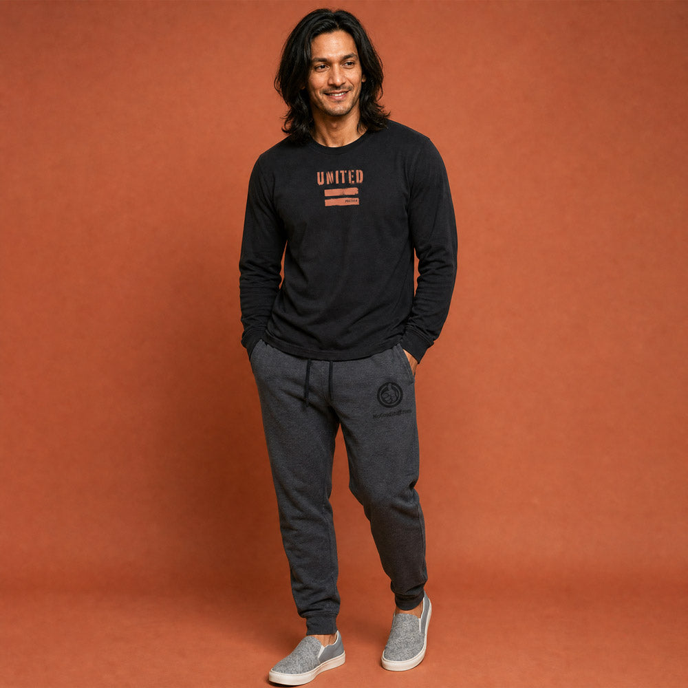 His Good Stuff's Autumn Catalog HGS26S4 United Equality, front, heavyweight, 100% ring-spun cotton, black, long-sleeve, detail of fabric against a flat Brandied Melon background. Graphic displays two bars beneath the distressed letters "EQUALITY".