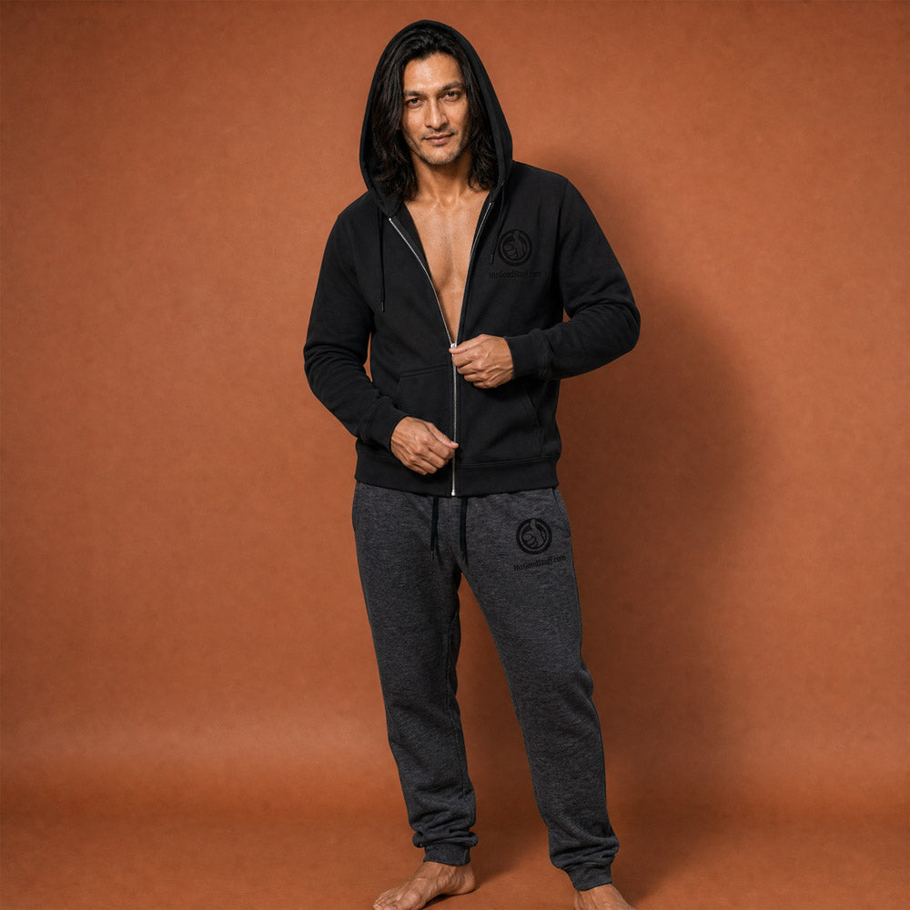 His Good Stuff's Autumn Catalog HGS26S4 Zip Hoodie, front, relaxed fit, black fleece, matching round drawcord with metal eyelets and tipped end, on a model against a flat Brandied Melon background. Graphic displays in the top right a black embroidered HGS Fall thumbs-up icon with HisGoodStuff.com underneath