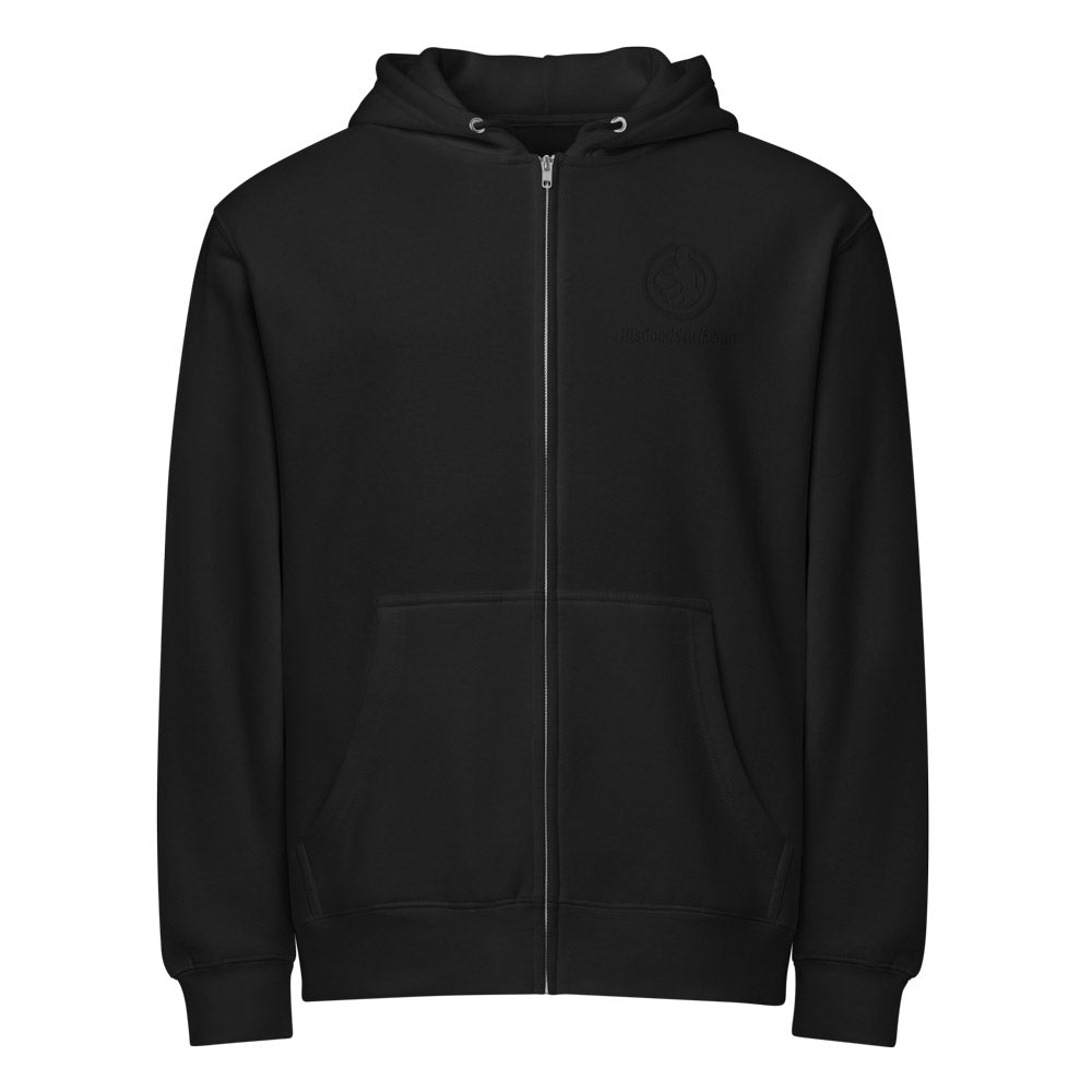His Good Stuff's Autumn Catalog HGS26S4 Zip Hoodie, front view, relaxed fit, black fleece, matching round drawcord with metal eyelets and a tipped end, on a model against a white background. Graphic displays in the top right a black embroidered HGS Fall thumbs-up icon with HisGoodStuff.com underneath